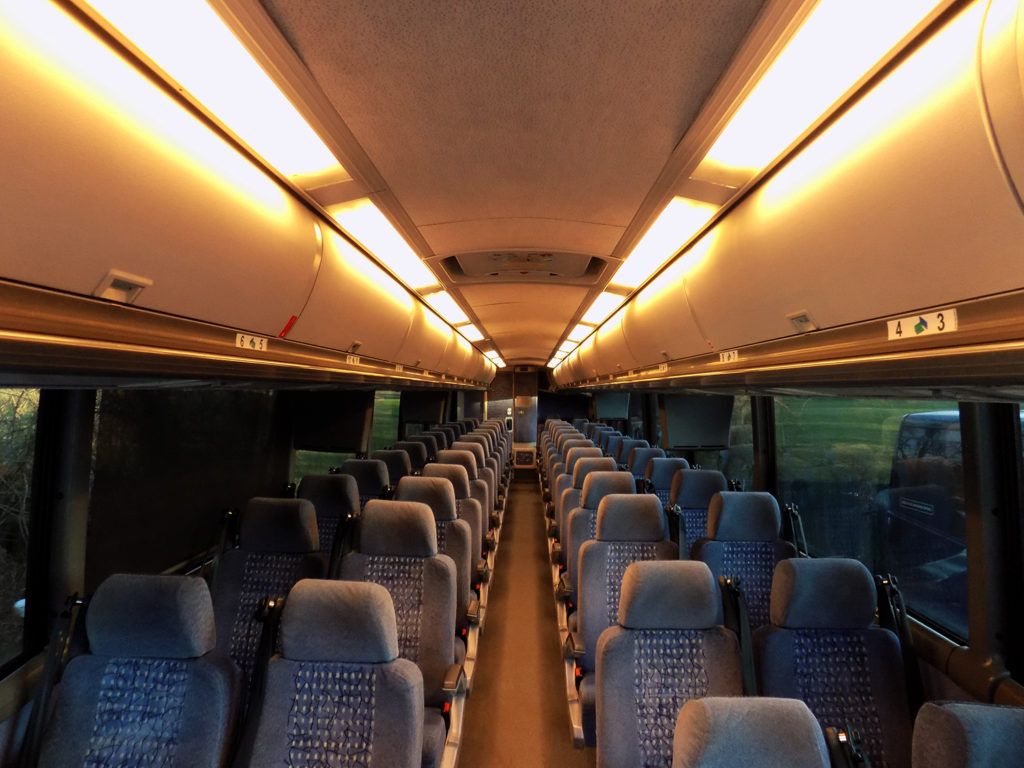 56 passenger charter bus interior with reclining seats and overhead lighting